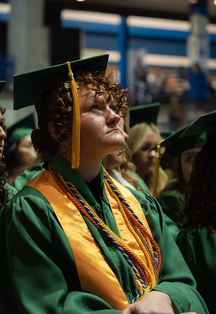 Graduate watching speakers at ceremony