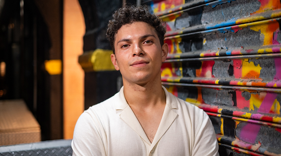 Diego Retana standing in front of graffiti wall