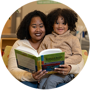 Woman reading story to child on her lap