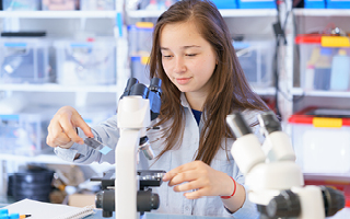 woman looking in microscope