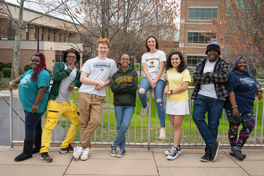 group of students in front of a college building smiling